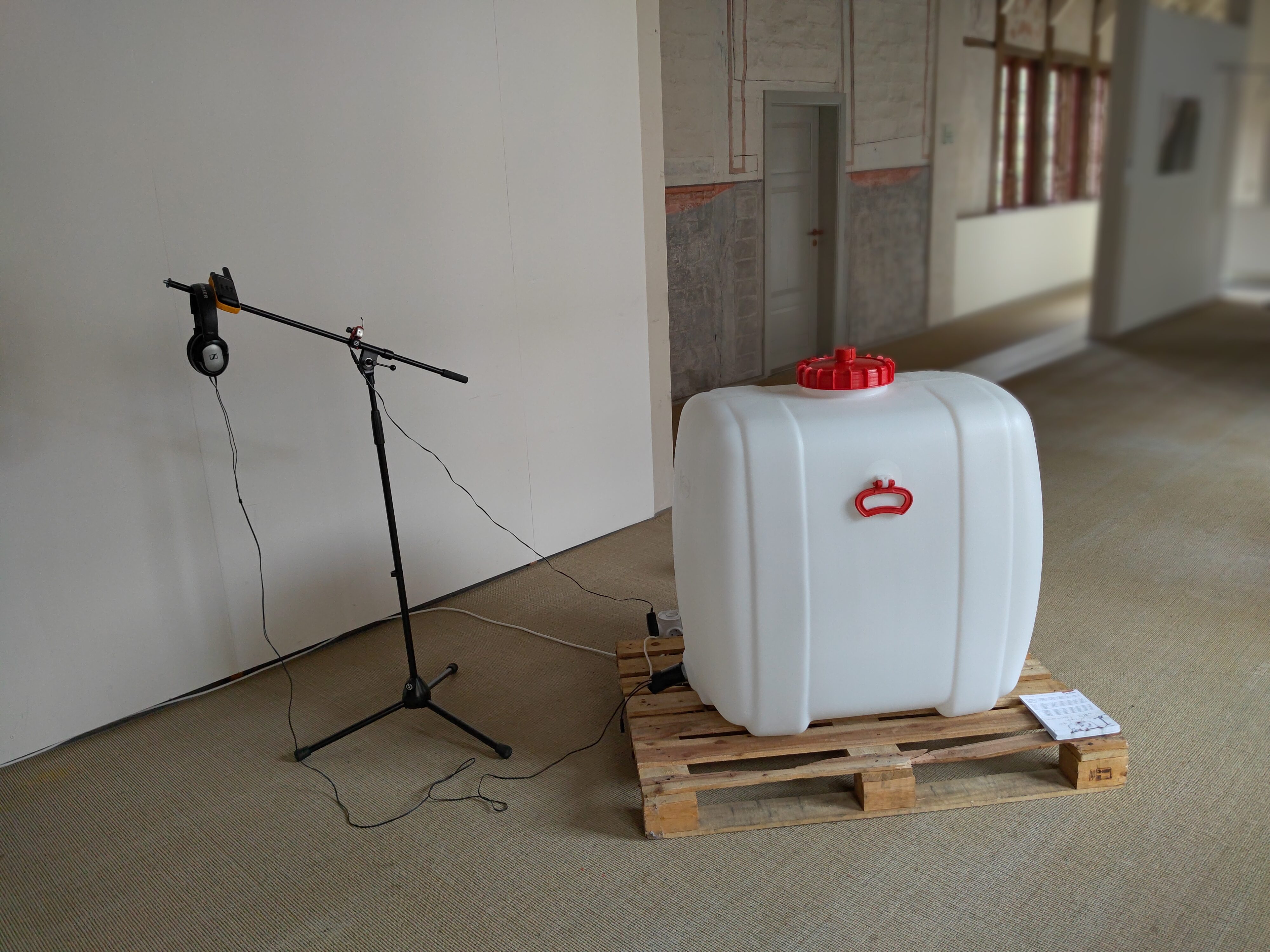 Sich selbst zum Totalklang, partizipative Installation., Heinrich-Heine-Haus, Lüneburg, 2024 (Foto: J.Georg Brandt). Wassertank, Funkgeräte, Funkkamera, Projektion.